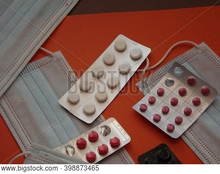 Light Blue Medical Masks And Colorful Covid 19 Pills. High Quality Photo