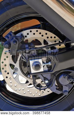 Motorcycling Ideas. Closeup Shoot Of Moto Rear Wheel Brake Disk With Abs Sensor And Brake Pistons.