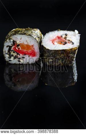 Japanese Cuisine Ideas. Macroshot Of Two Traditional Sushi Rolls With Salmon, Ginger And Orange Toge
