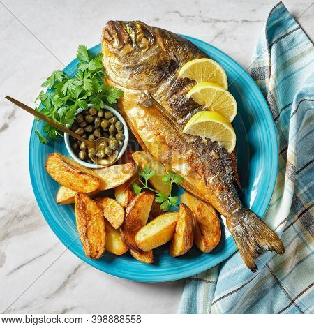 Grilled Sea Bream, Orata, Dorado Fish Served On A Plate With Roasted Potatoes And Mustard, Horizonta