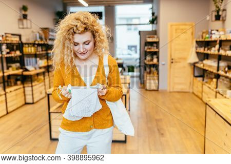 Blond Curly European Girl Is Holding Reusable Cup And Eco Bag. Cute Female During Shopping At Grocer
