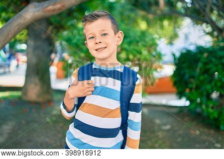 dorable caucasian student boy smiling happy standing at the park.