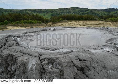 Bubbling Crater Of A Mud Volcano. Close Up View Onto Gas Bubble Exploding In Crater Of Mud Volcano. 