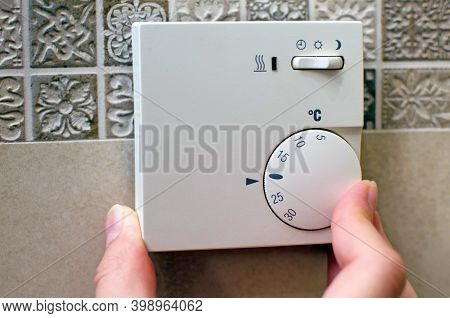 Closeup Of Hand Using Floor Temperature Controller At Home