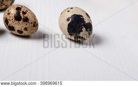Two Quail Eggs With Different Shells On A Light Wooden Table. Large And Small Drawing. Healthy Food 