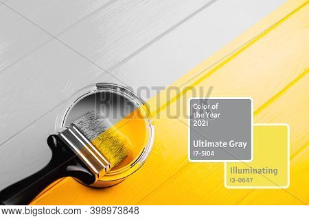 Paintbrush Is Applying On Yellow Half Freshly Painted Wooden Background. Repairing Concept. Gray And