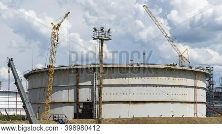 Refinery Factory Oil Storage Tank And Pipeline Steel At Day On Framatic Sky Background. Oil Refinery
