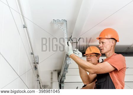 The Workers Are Installing Lift Gates In The Garage.