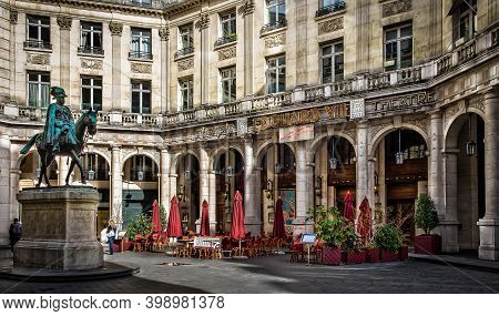 Paris, France, Fev 2020, Edouard VII square with the statue and the theatre of the same name and the terrace of Café Guitry