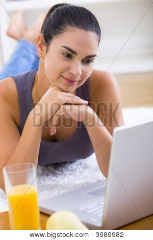 Frau auf Laptop zu Hause arbeiten