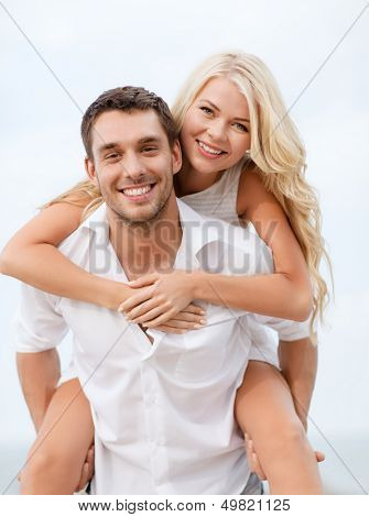 summer holiday, vacation, dating and tourism concept - happy couple having fun on the beach