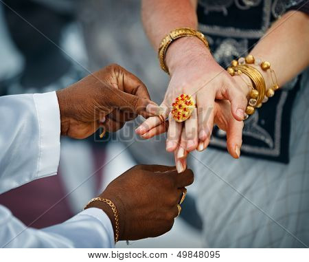 Wedding In Sri Lanka. Ritual - Priest Ties Little Fingers With A Thread