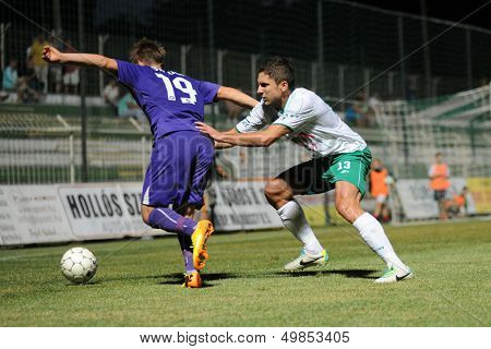KAPOSVAR, HUNGARY - AUGUST 16: Okuka Drazen (in white) in action at a Hungarian National Championship soccer game - Kaposvar (white) vs Ujpesti TE (purple) on August 16, 2013 in Kaposvar, Hungary.