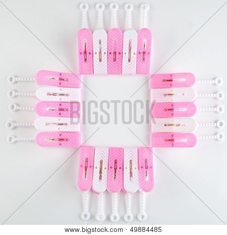 Clothespins arranged as square with whitel background