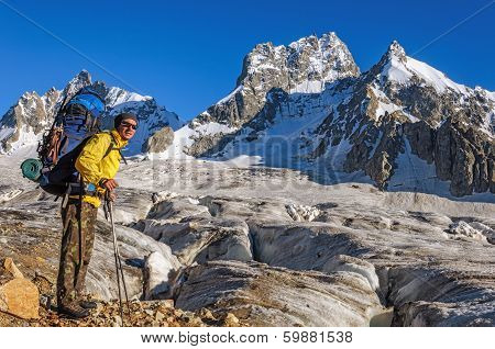 Hiker with a backpack on a glacier in the mountains of Georgia