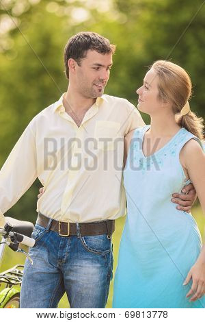 Young Couple In The Park With Bicycle