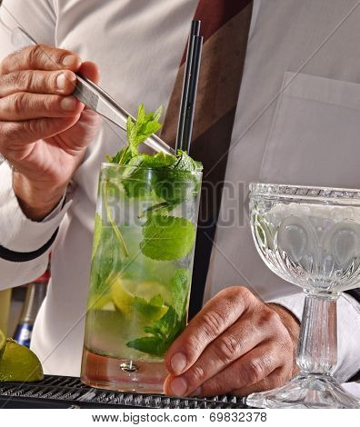 Barman preparing mohito cocktail.Bartender preparing cocktail.