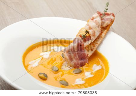Pumpkin Cream Soup Purée With Bread Slice, Bacon And Seeds