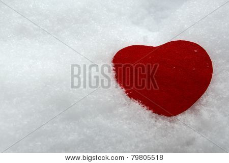 Red heart symbol on natural snow