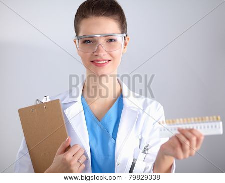 Attractive female dentist with tools , standing on gay