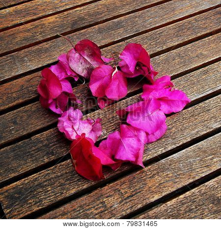 A heart from petals lying on a wooden table