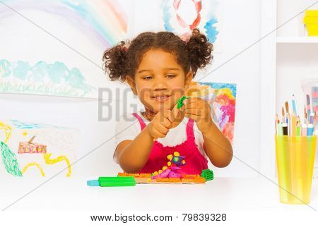 Little Hispanic looking girl play with plasticine