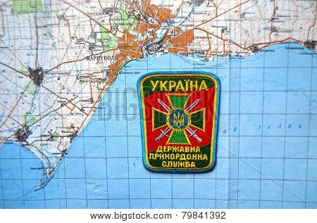 Illustrative editorial.Border guard of Ukraine chevron.With map of Mariupol. City and port on Azov Sea.At present time frontline.New Eastern border of Ukraine.At January 10,2015 in Kiev, Ukraine 