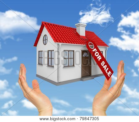 Female hands holding model house