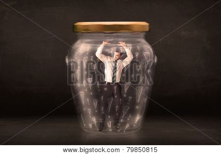 Business man trapped in jar with exclamation marks concept on bakcground