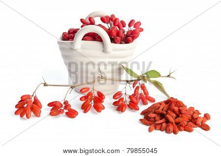 Porcelain Basket With Berberries Near Heap Of Goji Berries  Isolated On White Background