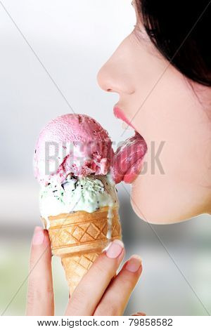 Young woman eating tasty ice cream