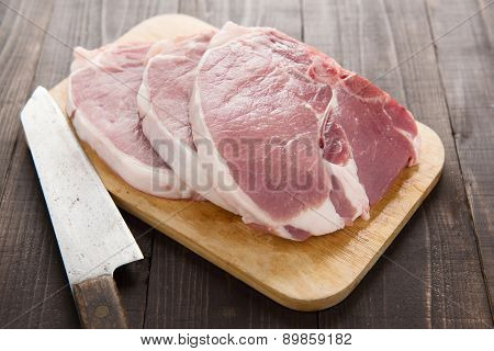 Raw Pork Chop Steak And Cleaver On Wooden Background