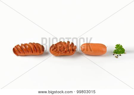 raw and roasted sausages on white background