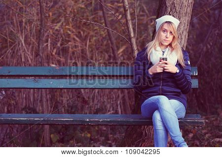 Young woman sitting on bench with her best friend