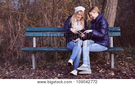 Young woman sitting on bench with her best friend