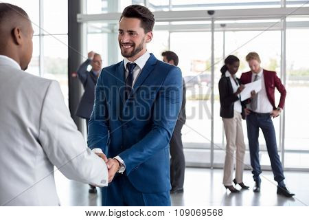 Handsome man at entrance heartily welcome black man