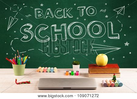 Back to school concepty with writing on blackboard and desk, apple, books, items