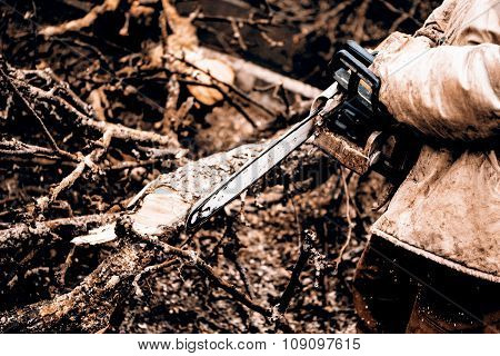 Man sawing a log in his back yard with orange saw