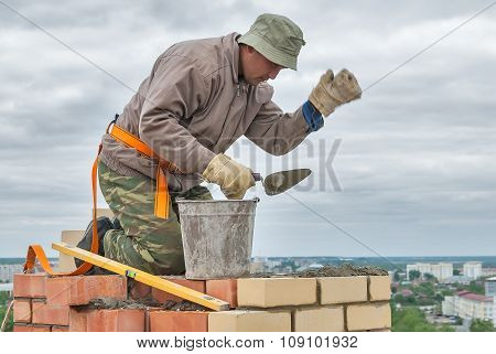 Bricklayer works on 15th floor of building