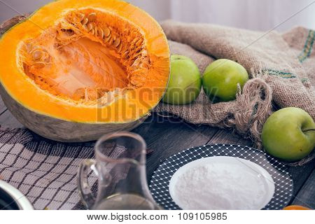 Preparing pie with pumpkins on wooden table, selective focus