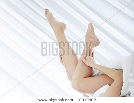 Benene på kvinden på sengen