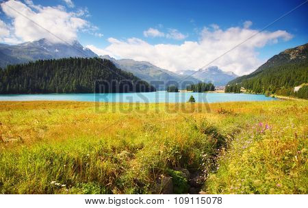 Fantastic azure alpine lake Champfer. Unusual and picturesque scene. Location famous resort Silvaplana village, district of Maloja in the Swiss canton of Graubunden, Europe. Beauty world.