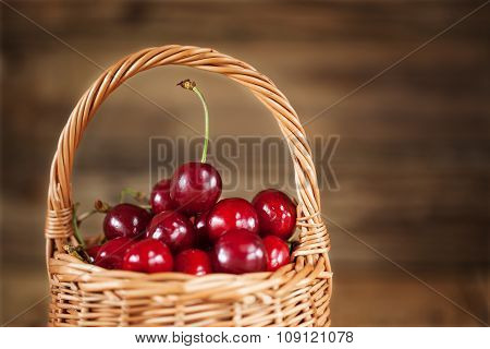 Ripe Sweet Cherries in  Basket closeup on Rustic Wooden background