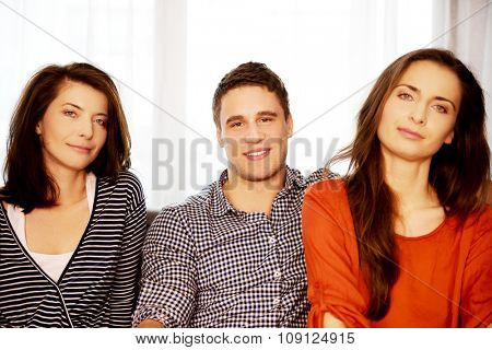 Sisters and brother sitting on the sofa.
