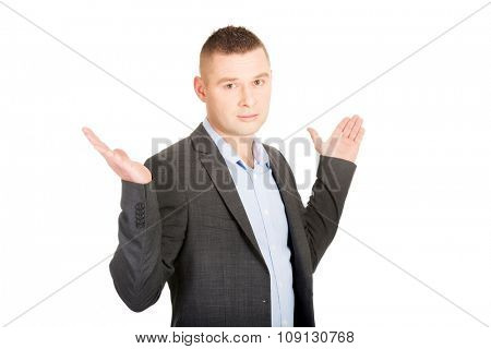 Young businessman making undecided gesture.