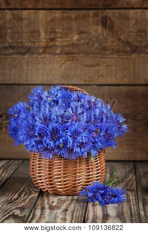 A bunch of beautiful summer flower of Cornflower in the basket. Concept of romantic.