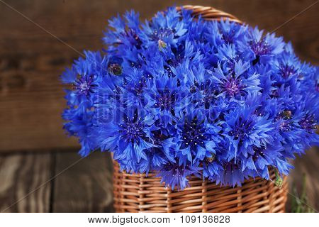 A bunch of beautiful summer flower of Cornflower in the basket. Concept of romantic.