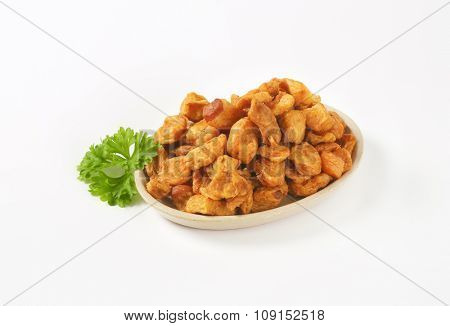 plate of salty pork greaves on white background