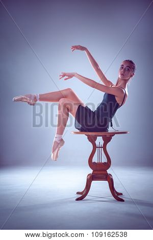 The silhouette of young ballerina on the wooden table