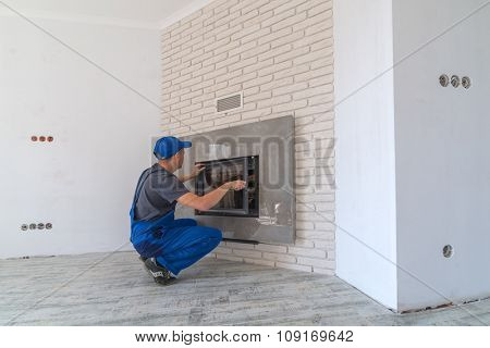 Fireplace installing in white brick wall